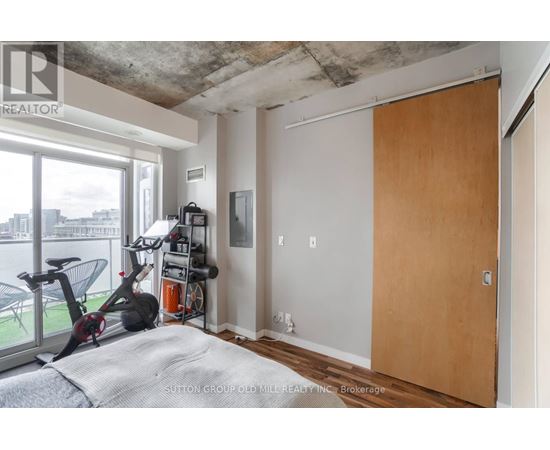 A room with a bed, a gym equipment and a window.