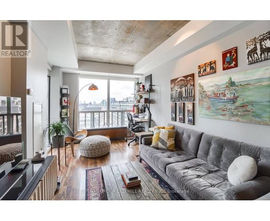 A living room with a grey couch and a large window.