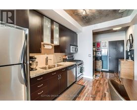 A modern kitchen with dark wood cabinets and stainless steel appliances.