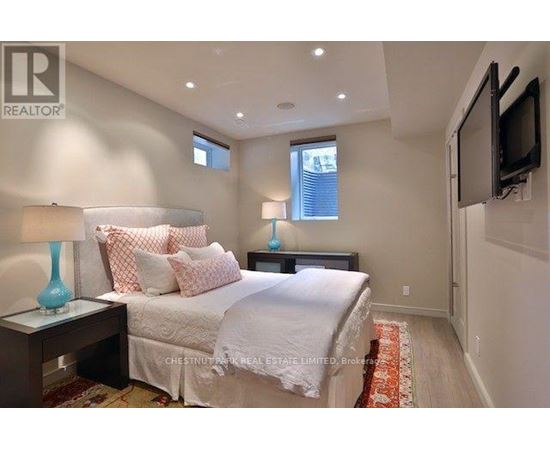 A bedroom with a bed, two lamps, and a television.
