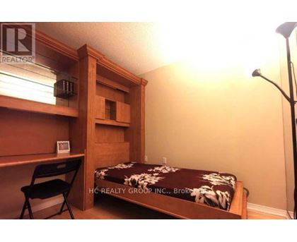 A bedroom with a bed, desk, and chair.