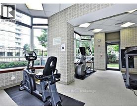 A gym with a treadmill, exercise bike and weights.