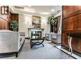 A living room with a grey sofa, a coffee table, and a fireplace.