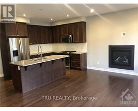 A modern kitchen with dark wood cabinets and a marble countertop.