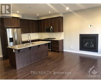 A modern kitchen with dark wood cabinets and a marble countertop.