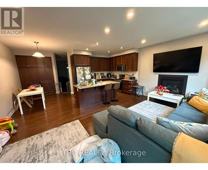 A living room with a grey couch and a television on the wall.