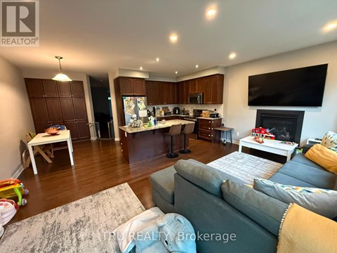 A living room with a grey couch and a television on the wall.