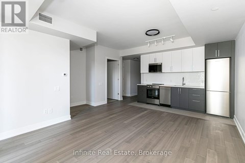 A spacious kitchen with white cabinets and stainless steel appliances.