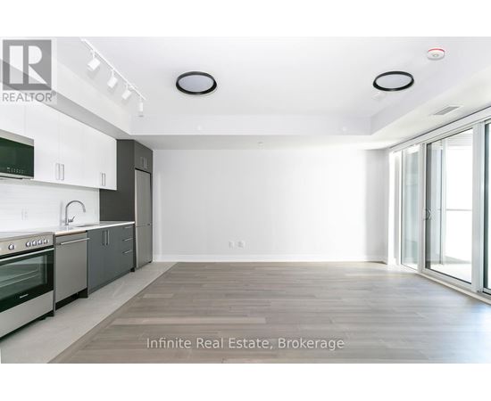A spacious kitchen with white cabinets and a large window.