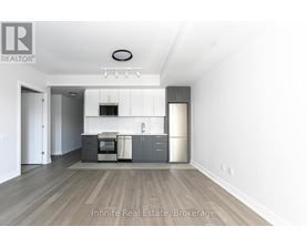A kitchen with a refrigerator, oven, and microwave.