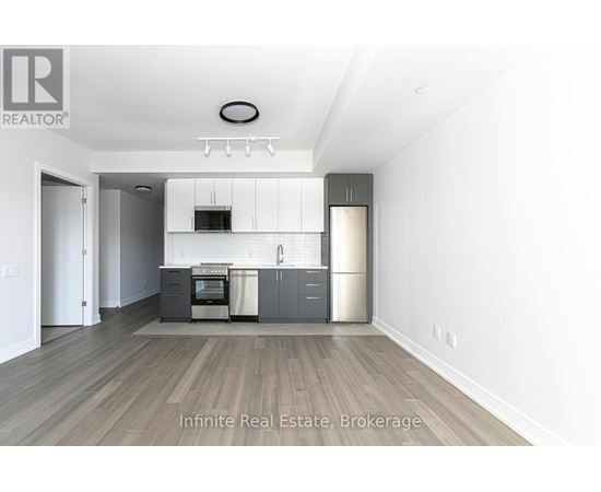 A kitchen with a refrigerator, oven, and microwave.