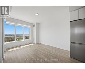 A spacious room with a large window overlooking a cityscape.
