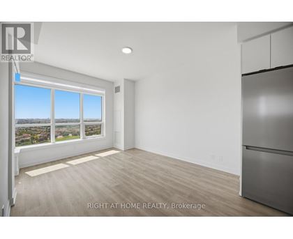 A spacious room with a large window overlooking a cityscape.