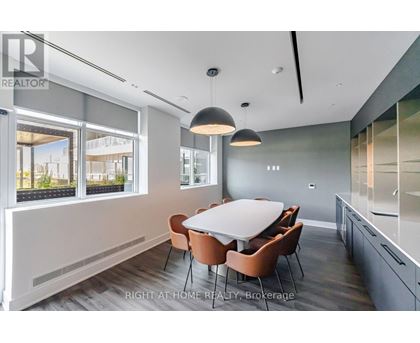 A dining room with a table and chairs.