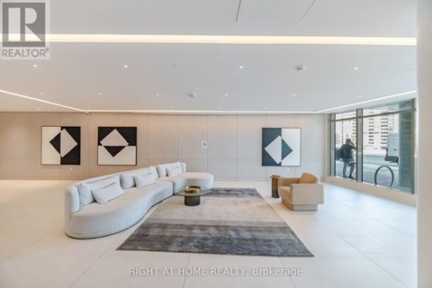 A spacious living room with a white sofa and a grey rug.