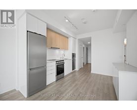 A modern kitchen with a refrigerator, oven, and cabinets.