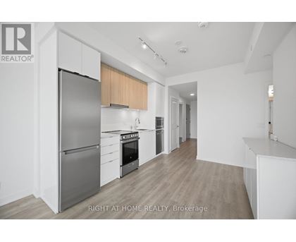 A modern kitchen with a refrigerator, oven, and cabinets.