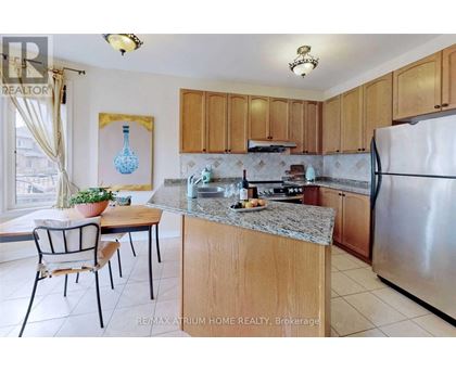 A kitchen with a table and chairs and a fridge.