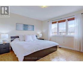 A bedroom with a large bed and a painting on the wall.