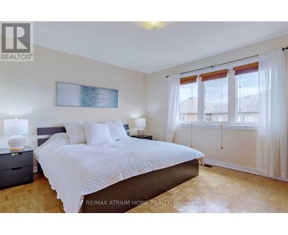 A bedroom with a large bed and a painting on the wall.