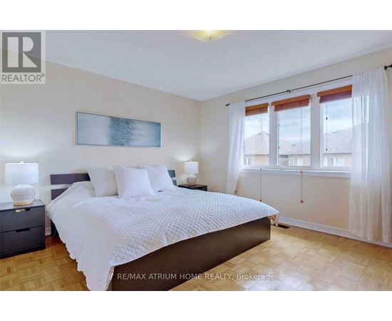 A bedroom with a large bed and a painting on the wall.