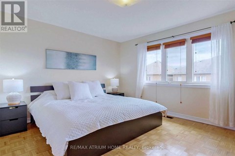 A bedroom with a large bed and a painting on the wall.