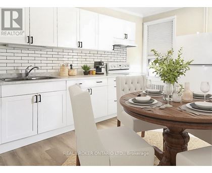 A white kitchen with a table set for two.