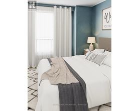 A bedroom with a white bed and a grey blanket.