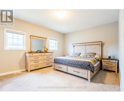 A bedroom with a bed, dresser, and mirror.