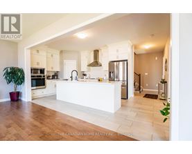 A modern kitchen with a white counter and wooden floors.