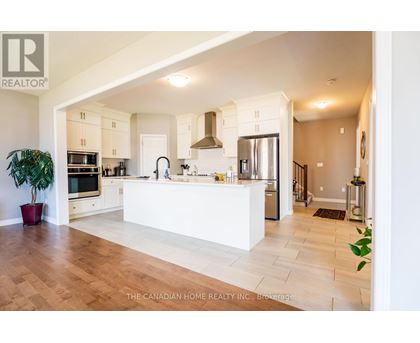 A modern kitchen with a white counter and wooden floors.