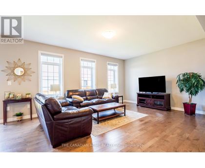 A living room with a leather couch and a flat screen TV.