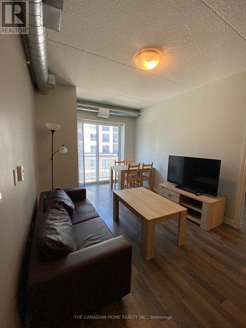 A living room with a brown leather couch and a wooden coffee table.