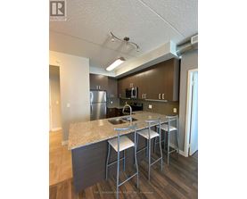 A kitchen with a granite countertop and stainless steel appliances.