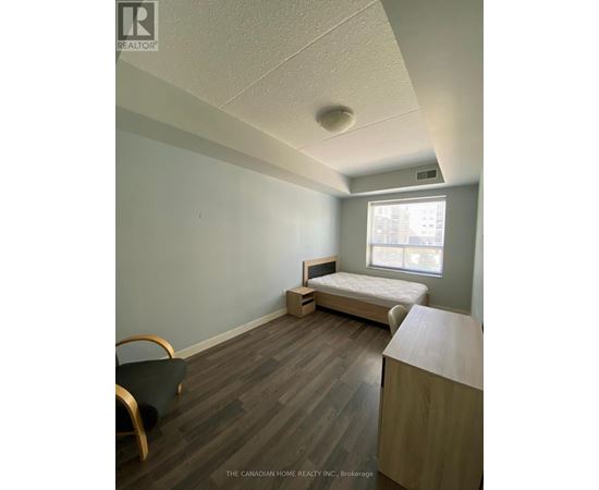 A bedroom with a bed, chair, and window.