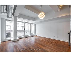 A large, empty room with wood flooring and a large window.