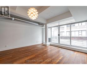 A room with wooden floors and a large window overlooking a city street.