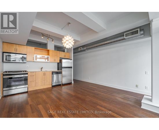 A kitchen with wood floors and stainless steel appliances.