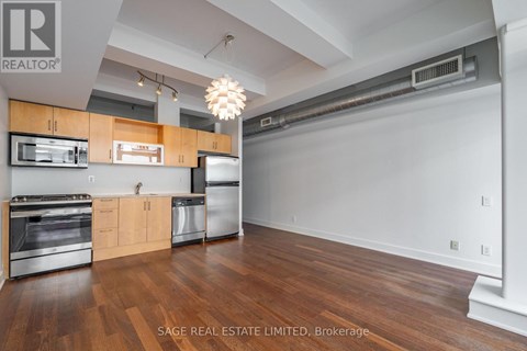 A kitchen with wood floors and stainless steel appliances.