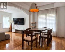 A dining room with a wooden table and chairs.