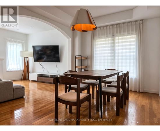 A dining room with a wooden table and chairs.