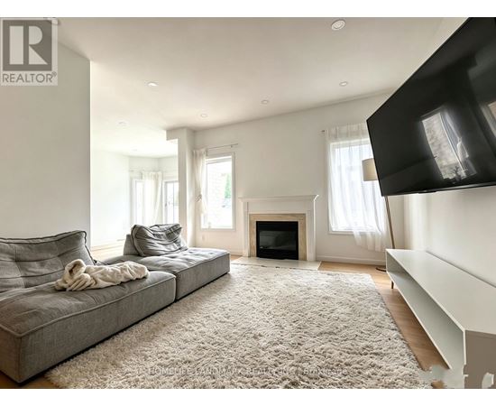 A living room with a grey couch and a fireplace.