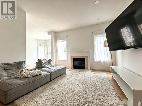 A living room with a grey couch and a fireplace.