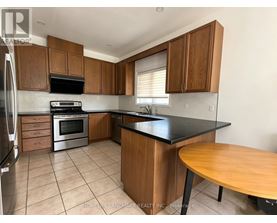 A kitchen with wooden cabinets and a black countertop.