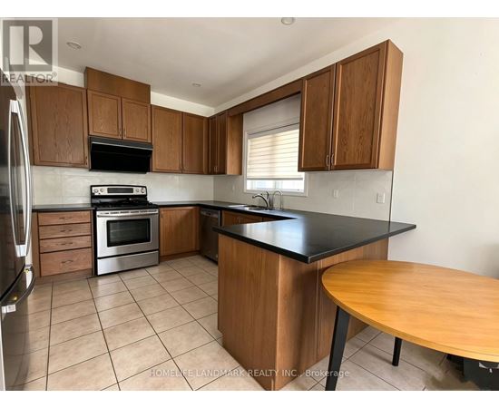 A kitchen with wooden cabinets and a black countertop.