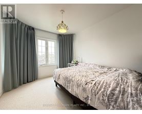 A bedroom with a large bed and a window with curtains.