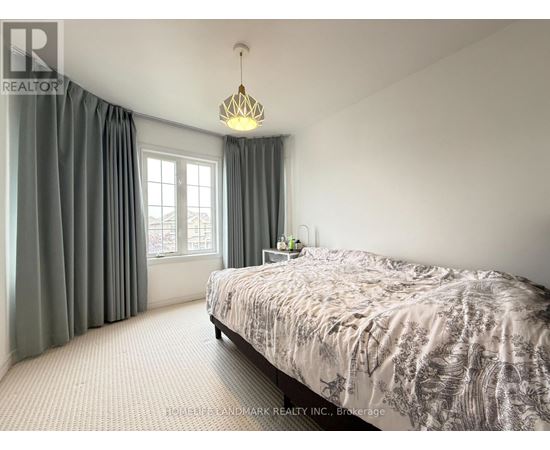 A bedroom with a large bed and a window with curtains.
