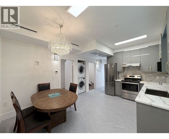 A modern kitchen with a wooden table and chairs.