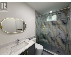 A bathroom with marble countertops and a walk-in shower.
