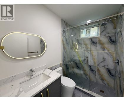 A bathroom with marble countertops and a walk-in shower.